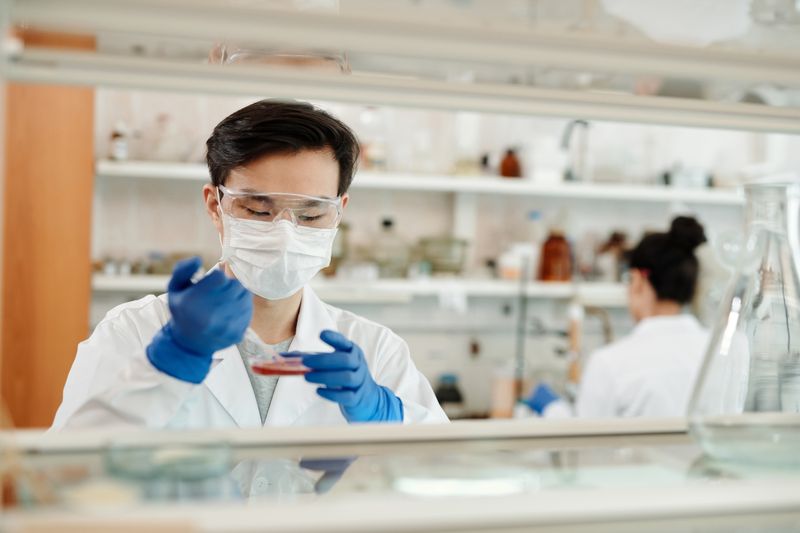 Investigadora observando muestras a través de un microscopio de laboratorio